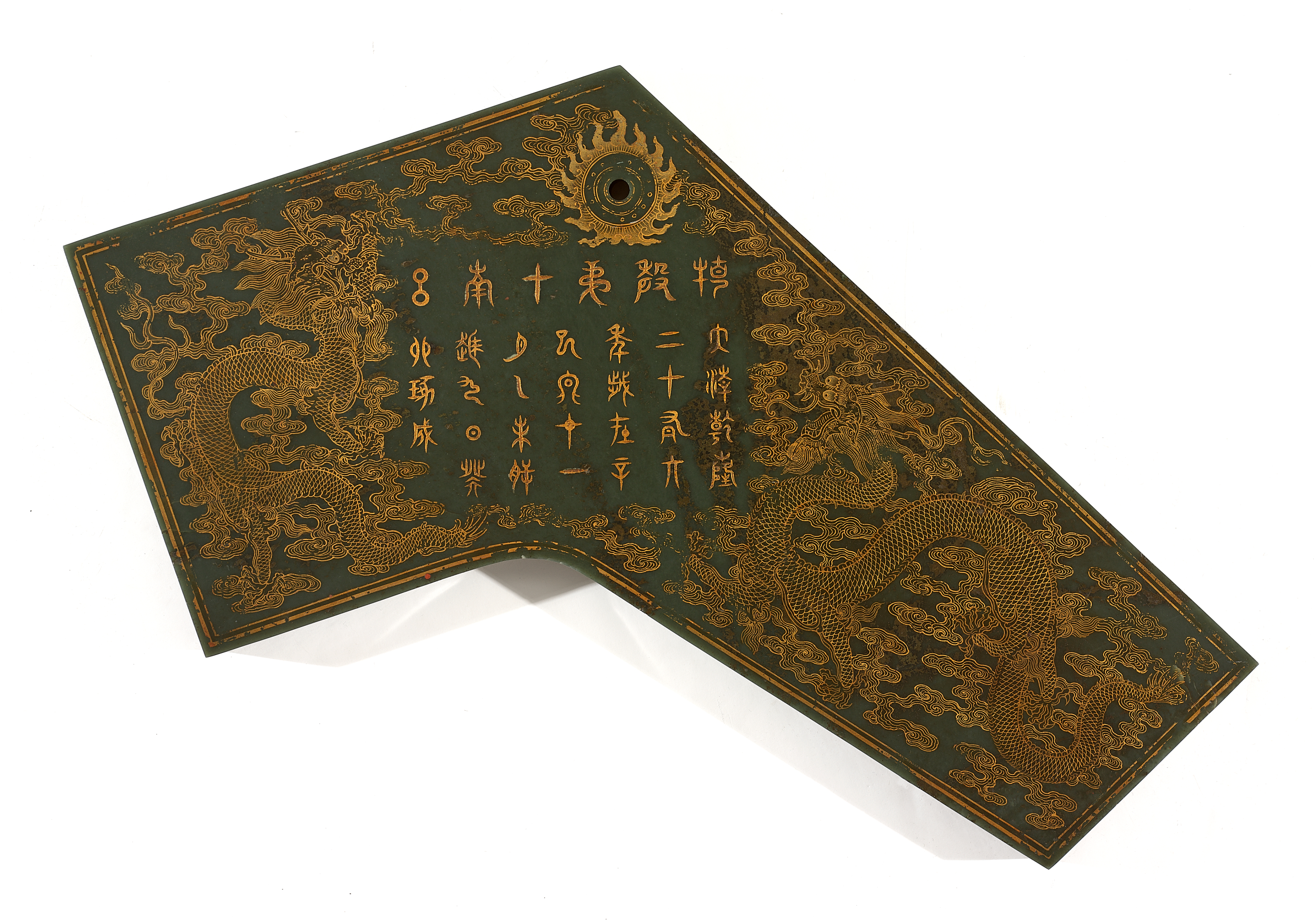 Dark green slab which slopes sharply down to the right, with a dark circle at the top. Features intricate golden embellishments depicting Chinese characters surrounded by dragons above clouds.