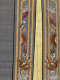 Two bordered edges of a gray textile, separated by a yellow silk strip. The borders show sinuous red dragons framed by gold stripes and surrounded by cloud and bird motifs.