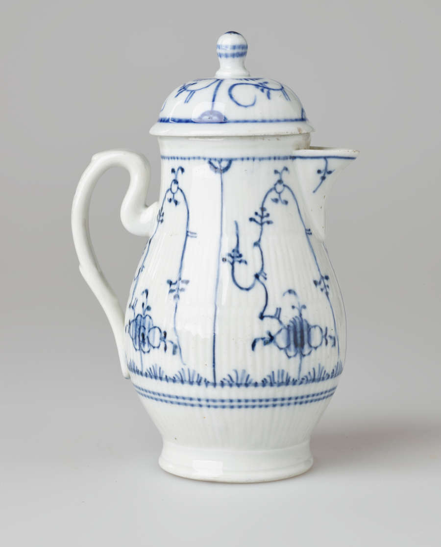 A white chocolate pot with delicate blue decorations with ribbed body, spout, handle, and foot.