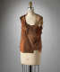 A sleeveless sheer top constructed of layered brown tones draped on a dress form, with exposed seams. 