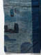 A fragment of indigo fabric with multiple irregular patches in various shades of blue and hand stitching. 