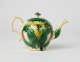 A bulbous teapot with white, green, and yellow floral decorations in the form of a leafy pineapple.