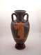A ceramic vessel with twisted handles and ornate orange design of a figure holding a staff set on a black surface.
