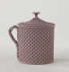 A purple covered cup with raised woven texture. The handle is sculptural and swirled.