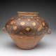 A large, rounded clay vessel with a narrow rim and two small handles,  decorated with red and black lattice.
