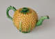A teapot in the shape of a pineapple. Handle, foot, lid, and spout are green.
