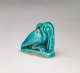 Turquoise amulet at an angle, of a crouching pelican-like bird with a long beak pointed downwards, head tucked into its neck, where there is a small loop.