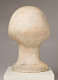 Back view of a blemished marble sculpture depicting a head with a short hairstyle. The marble is bruised, featuring faint patches of red. N. Elizabeth Prophet is carved at the base.