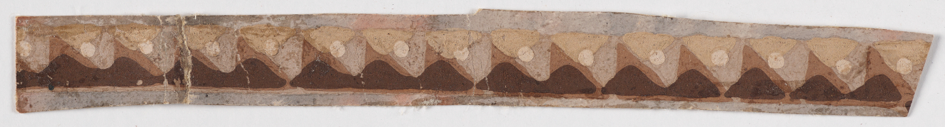 Beige ornamental border strip on a light background. Features repeating brown waves accented by beige triangles and subtle dot embellishments. To the left is a prominent crack in the strip.