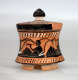 A small, flared, terracotta container with a black-glazed lid, adorned with black figures in flowing robes, holding instruments.