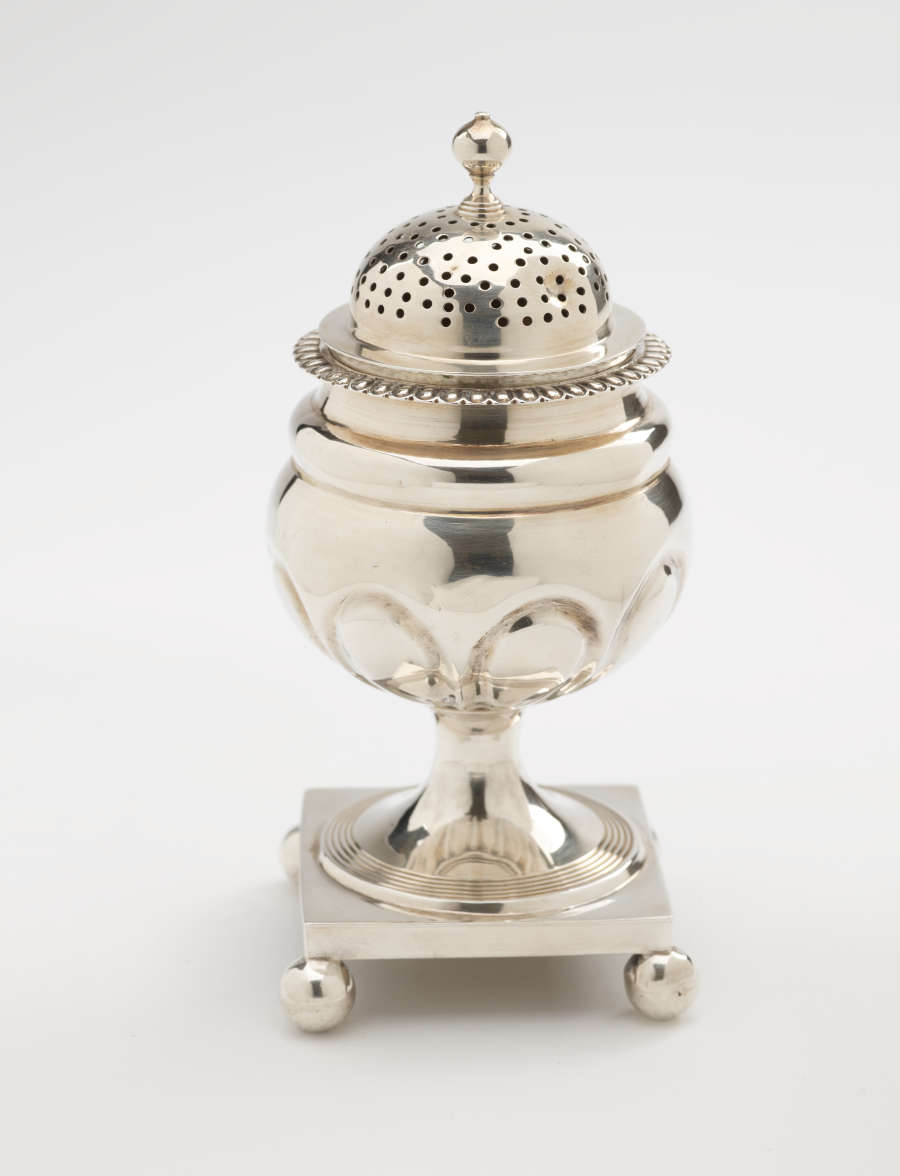  A silver caster with a square foot with small balls in each corner, the lid is perforated.
