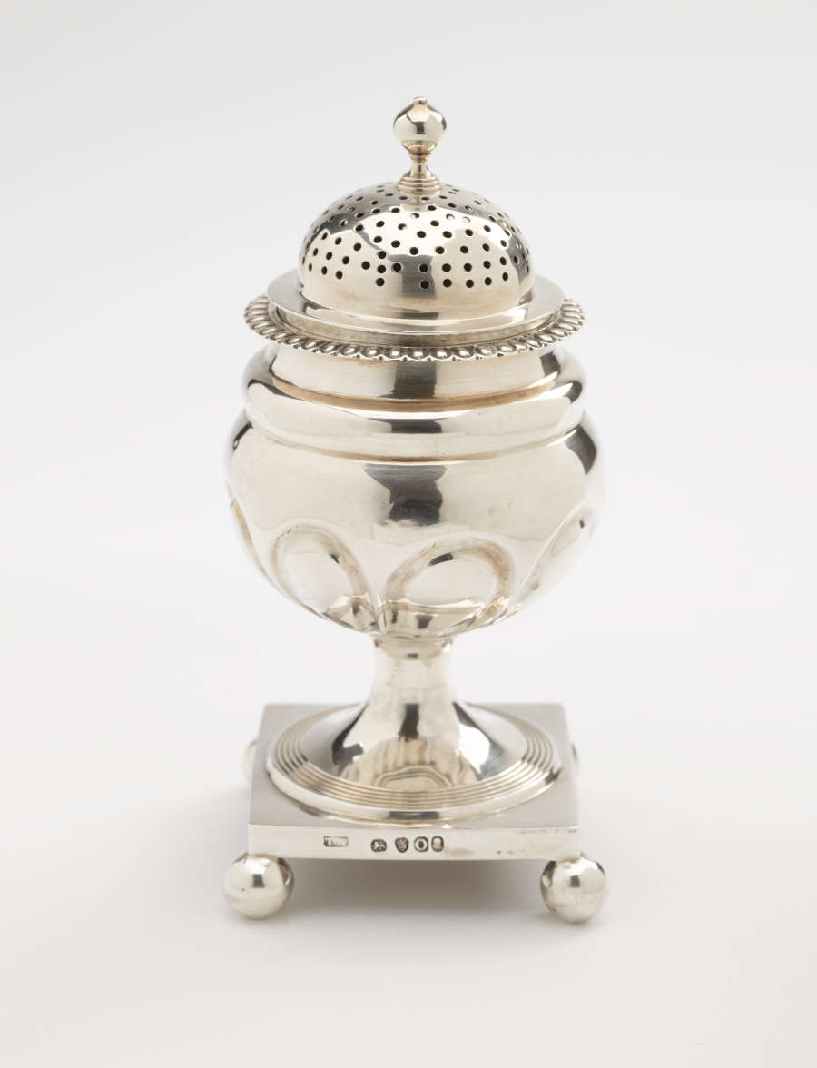  A silver caster with a square foot with small balls in each corner, the lid is perforated.
