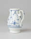 A white chocolate pot with delicate blue decorations with ribbed body, spout, handle, and foot.