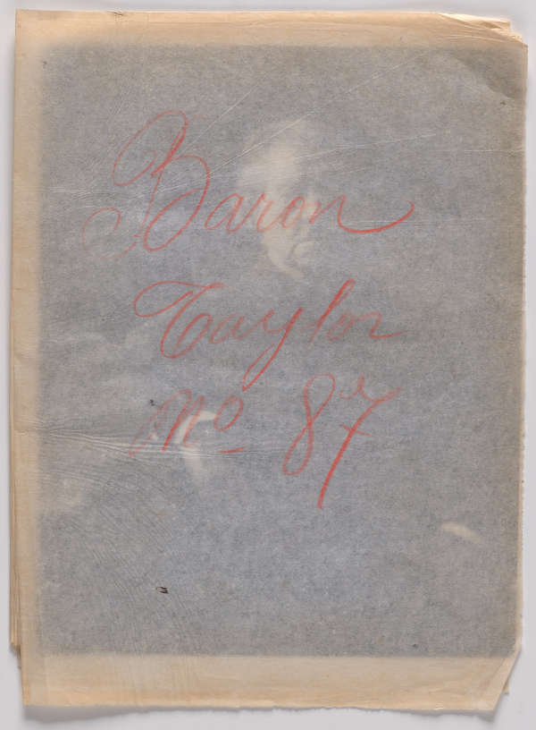 A translucent sheet with writing in red reading, “Baron Taylor no_87” covering a black and white portrait.