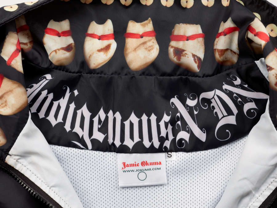 The jacket’s white interior, showing that the tooth-like motifs continue on the inside of the collar. The upper jacket’s interior is black with ‘Indigenous NDN” written in white Gothic lettering.