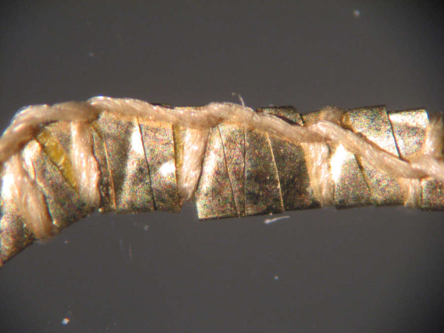 Chemise, ca. 1923; magnification reveals that the thick yarn has been hammered flat and encased in looped thread, which was used to attach the yarn to the dress.