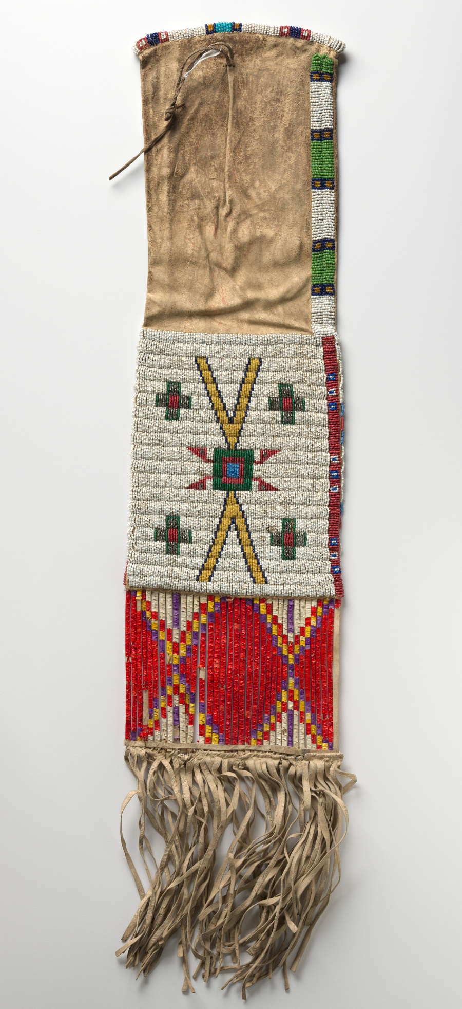Long deerskin case with geometrically patterned white, red, blue, yellow, and green beading on the fringed bottom half as well as the sides. A string tie secures its mouth.