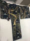 A dark blue kimono adorned with gold willow trees and white birds, displayed flat on a white surface.