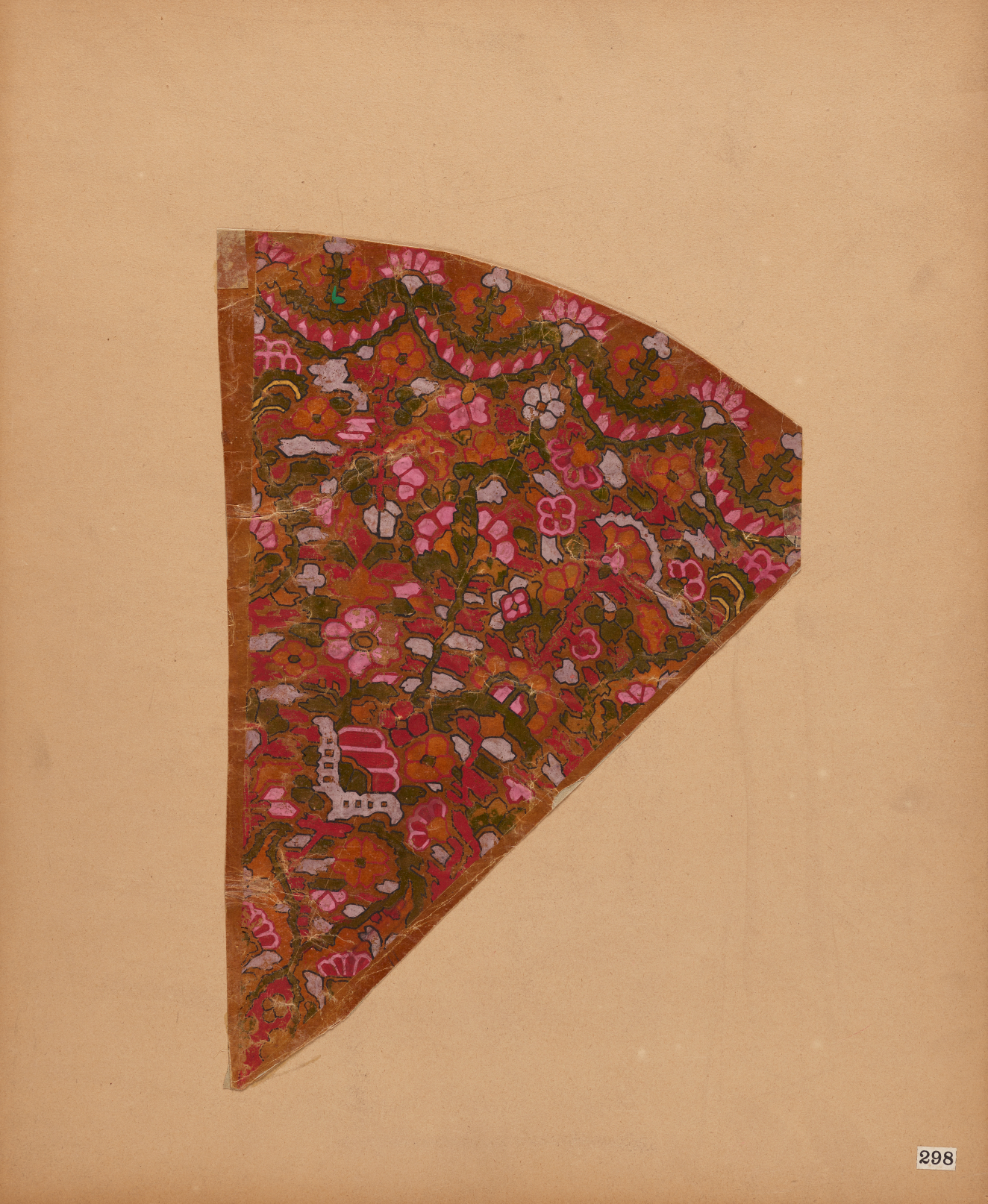 A triangular shaped fragment with intricate pink, red, and green designs with a curved edge along the top. Painted on aged paper.