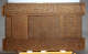 A panel of a carved wooden box, with intricate calligraphic inscriptions, and geometric and floral designs. 