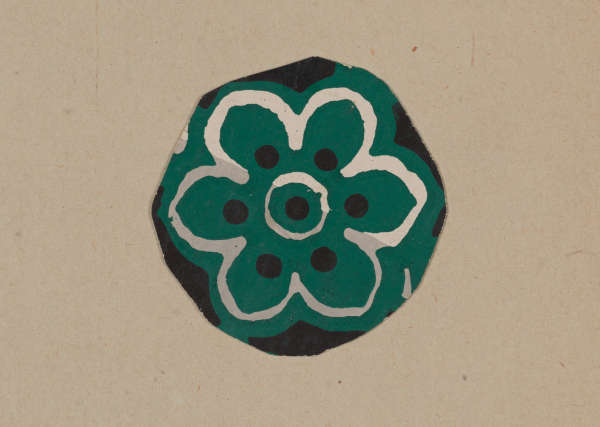 A circular green floral motif with six symmetrical petals outlined in white, with a black circular center and black dot accents.