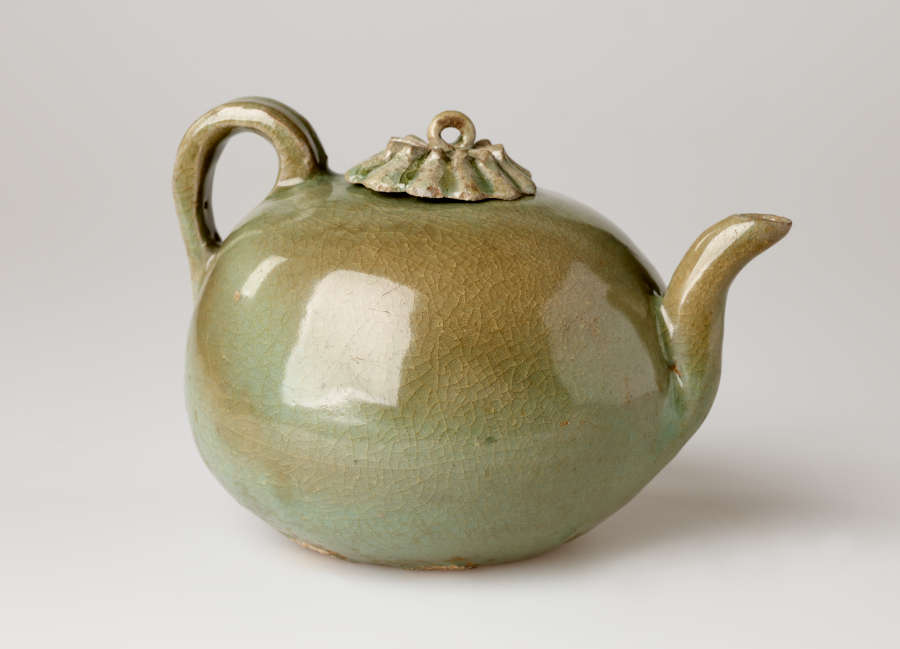 A rounded greenish brown water kettle with a handle, spout, and small decorative lid and a loop for a finial.
