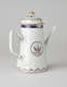 A white coffee pot with dark blue and gilded decorations, a straight spout, angular handle, and heraldry imagery in a circle on the body of the coffee pot.