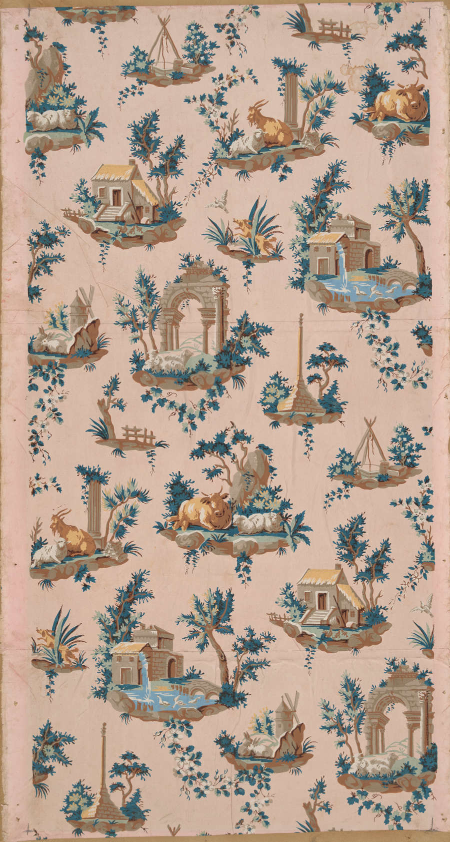 Tall panel of vintage wallpaper featuring a diagonal pattern of bucolic pastoral and architectural scenes amidst lush blue florals on a pale pink background.