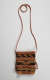 Woven rectangular bag with a long strap laying flat on the white backdrop. Its body features three rows of terracotta separated by three rows of yellow bordered terracotta geometric patterns against black.