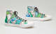 High top sneakers with a bright hand-painted blue and green abstract design and black laces.