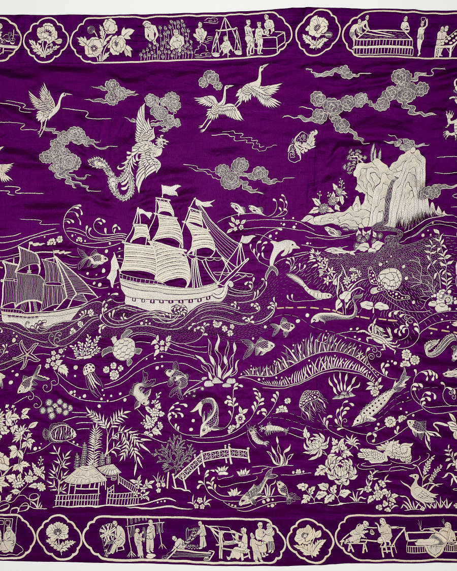 Detail from a purple and white embroidered textile depicting many scenes along a trade route, such as sailing ships, laborers and scenes of leisure.