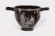 Rounded black vessel with wide handles featuring an illustration of a nude man besides a seated woman wearing draped fabric holding a bird, surrounded by ornamental patterns.