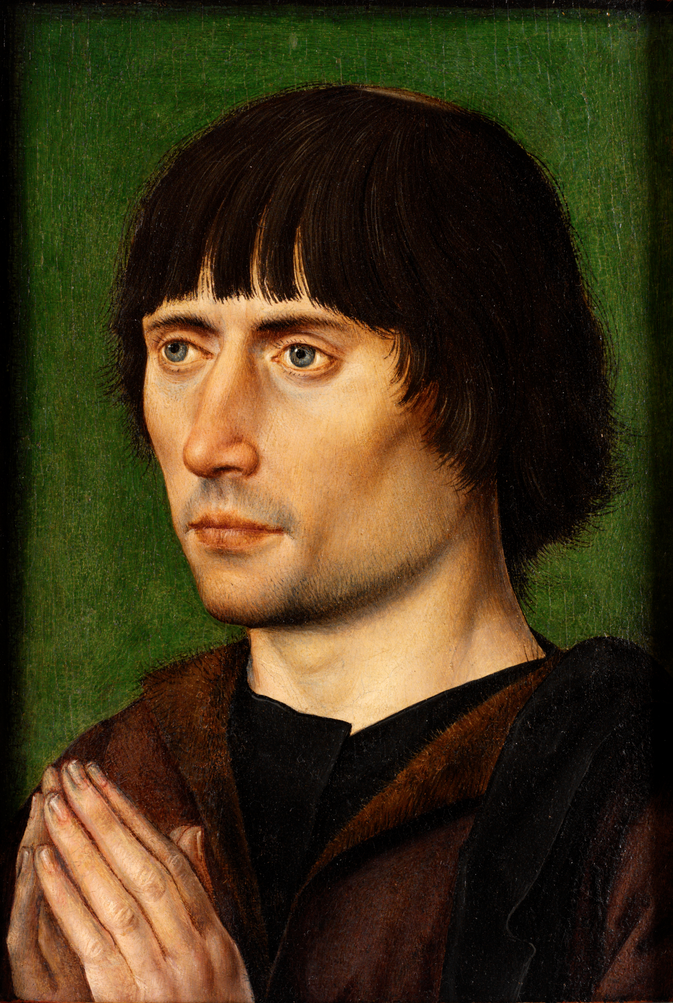 Realistic painting of a fair-skinned man in brown robes with straight dark hair, gazing solemnly to the side, hands in a prayerful position against a green background. 