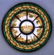 Circular surface of a central image surrounded by eight detailed scenes of landmark buildings in radiating panels, encircled by bright green and gold geometric mosaic patterns. 