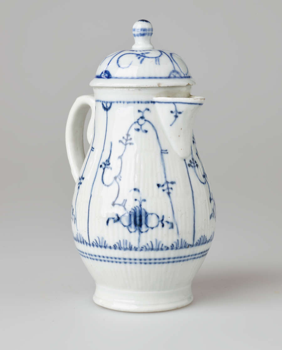 A white chocolate pot with delicate blue decorations with ribbed body, spout, handle, and foot.