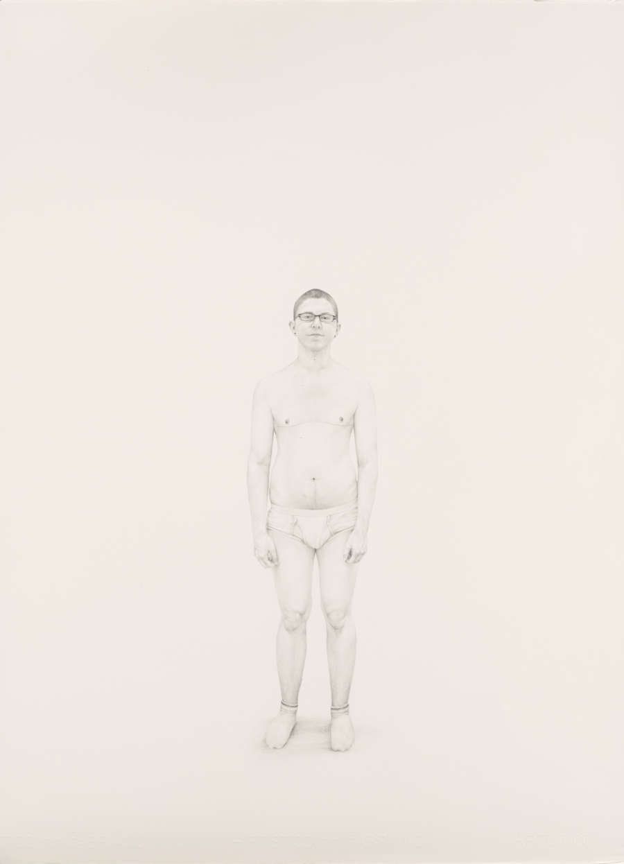 Precise, lightly rendered drawing of a young man standing in only briefs, socks, and glasses. He looks at the viewer. There are faint horizontal scars on his chest.