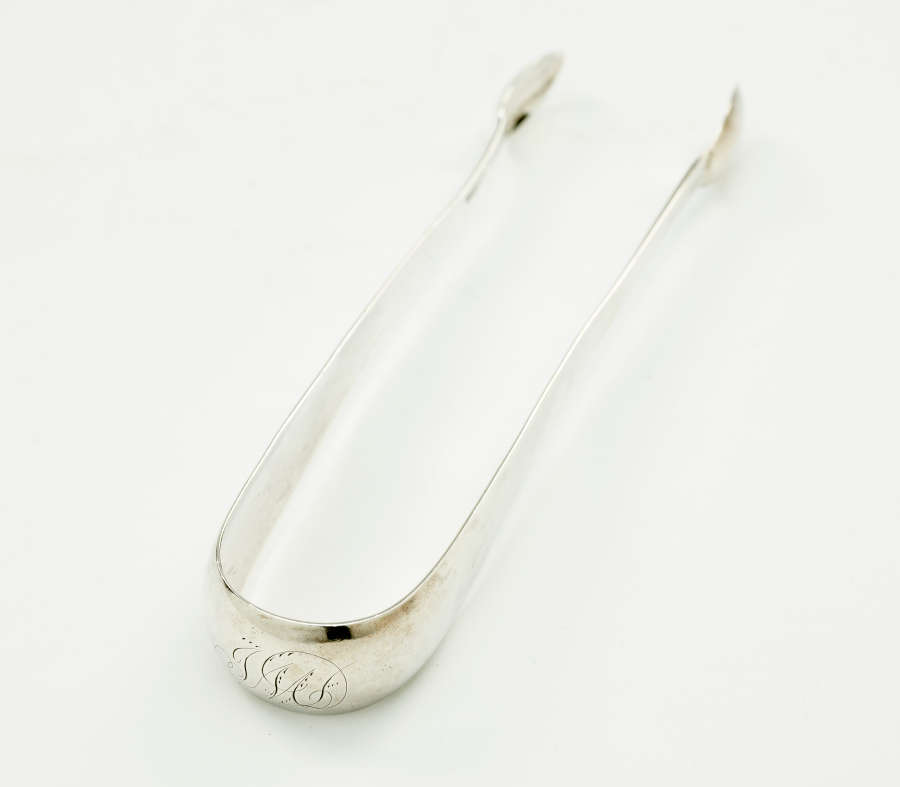 Silver sugar tongs with small ends and a thicker handle portion.
