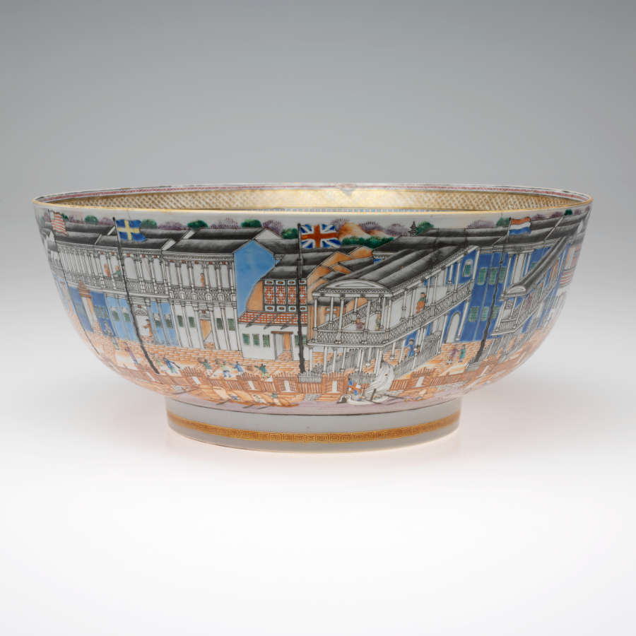 A ceramic bowl ornamented with a vibrant, bustling cityscape including buildings, figures, and boats in vivid colors and fine details. 