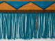 Close-up of the fringed ends on a turquoise,yellow, and beige woven fabric with geometric patterning. The fringed ends are mainly turquoise with one contrasting short orange strand. 