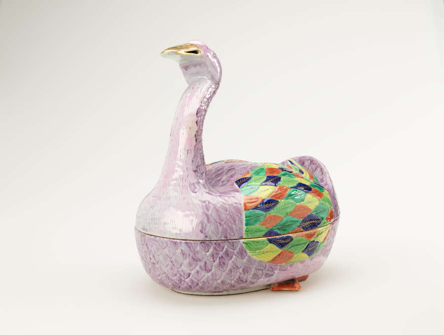 A sculptural vessel in the shape of a goose. The purple body is accented with diamond-shaped decorations in green, blue, yellow, and orange.