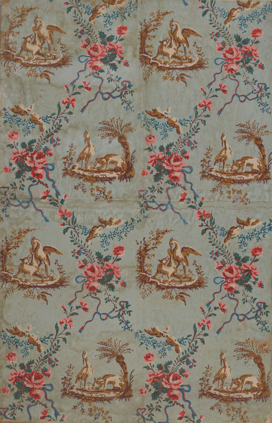 Segment of vintage wallpaper featuring a pattern of repeating brown illustrations of wildlife in nature, surrounded by vibrant, decorative floral chains and foliage motifs; set on a faded blue background.