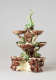 An elaborate, sculptural, three-tiered dish. Colored in brown, green, and cream with floral decorations as well as sculpted fish decorations.