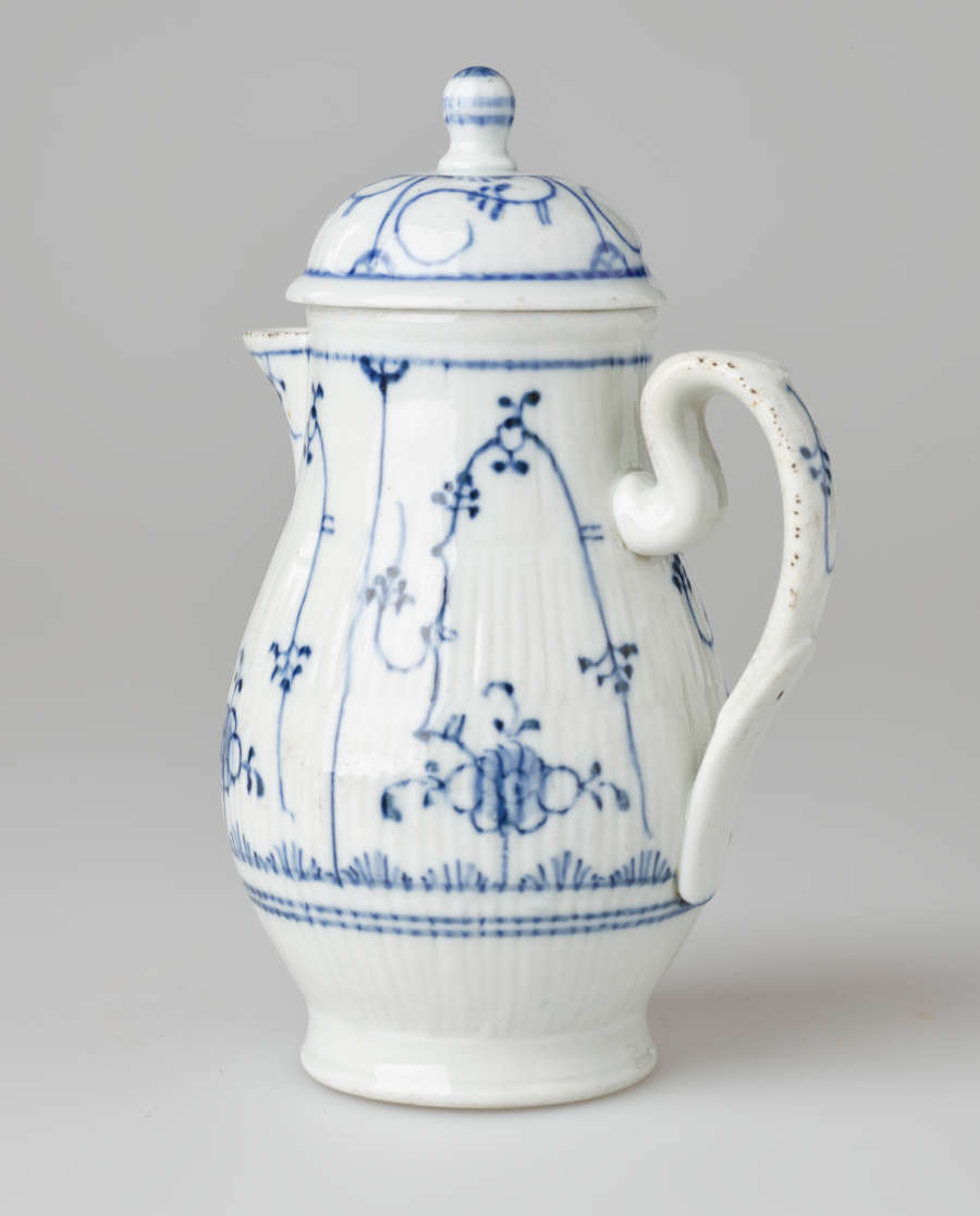 A white chocolate pot with delicate blue decorations with ribbed body, spout, handle, and foot.