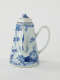 A white and blue teapot with floral decorations, a lid with a small semi spherical finial, spout, and a handle which is located approximately 90 degrees from the spout.