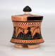 A small, flared, terracotta container with a black-glazed lid, adorned with black figures in flowing robes, holding instruments.
