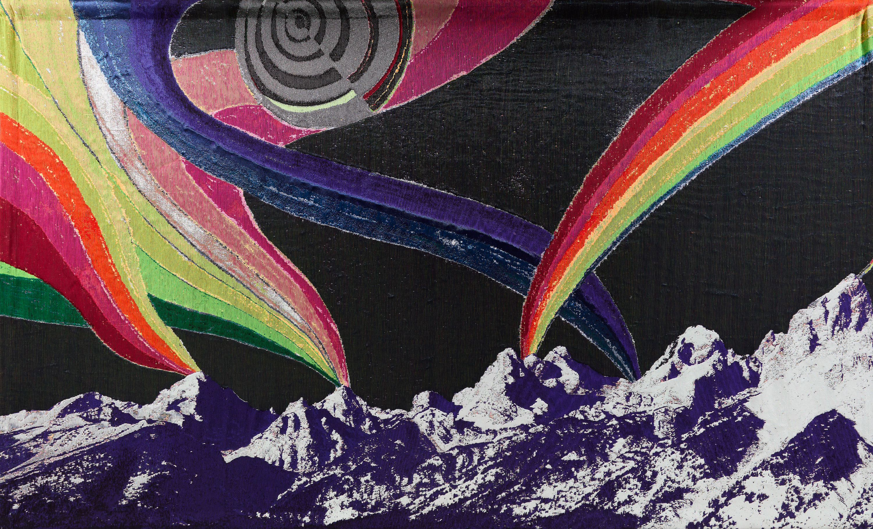 A woven wall-hanging with purple and white mountains in the foreground and vivid rainbows swirling out of the mountain peaks against a black sky. 