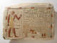 A carved and painted stone slab depicting an Egyptian nobleman in profile, surrounded by hieroglyphs and objects. 