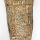 Close up of an intricately decorated coffin featuring hieroglyphic inscriptions flanked by colorful human figures.