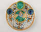 A lead-glazed earthenware plate that has different compartments. There are yellow, white, blue, and green glazed decorations.