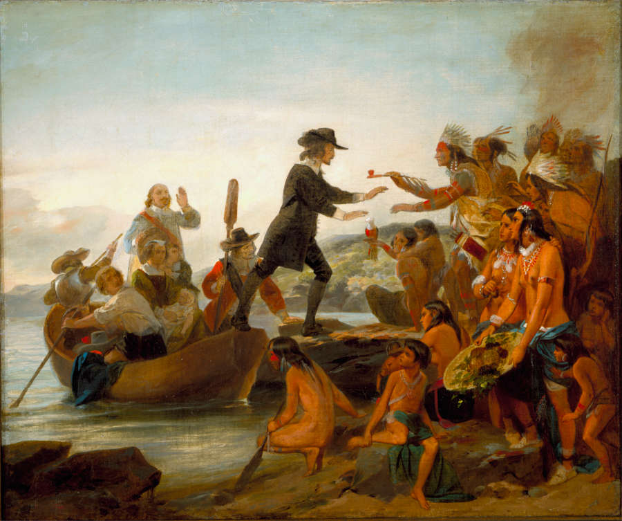 A fully clothed European man steps out of a crowded longboat onto the shore, where he is greeted by several Indigenous people bearing gifts, who are stereotypically depicted as minimally clothed.
